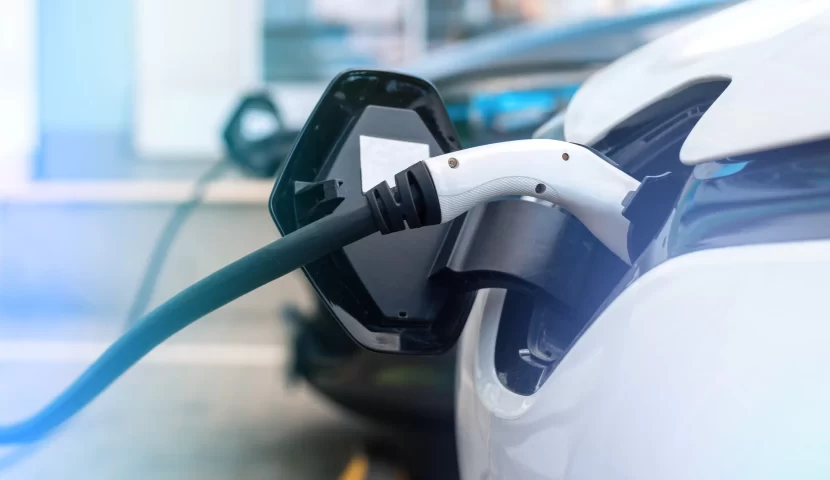 Two electric cars plugged into charging stations