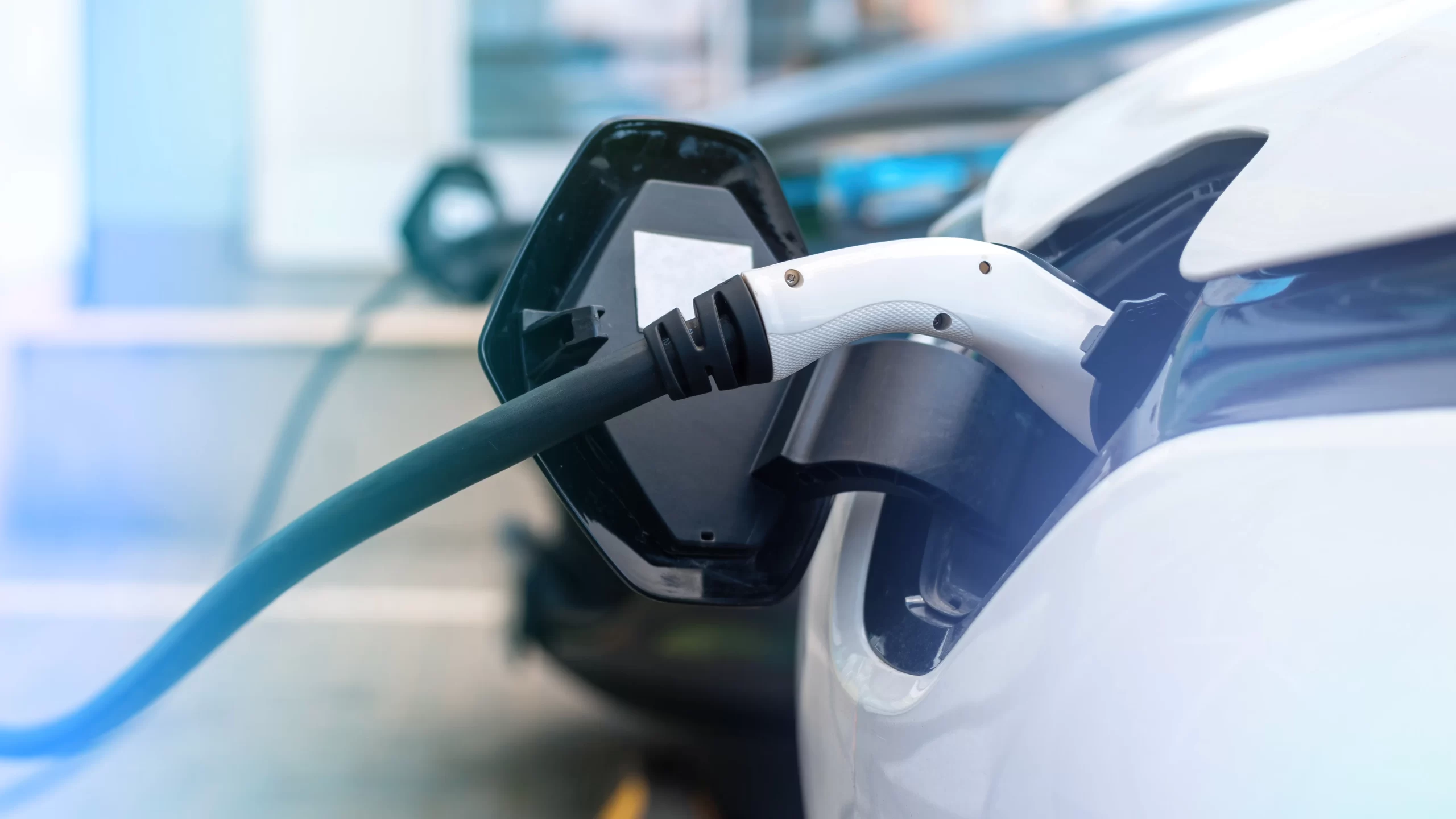 Dos coches eléctricos enchufados a puntos de recarga